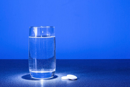 杯子里的水和桌子上的药。透明