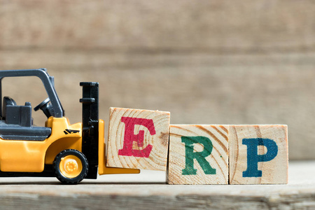 玩具黄色叉车举行字母块 E 完成词 Erp 企业资源计划的简称 在木头背景