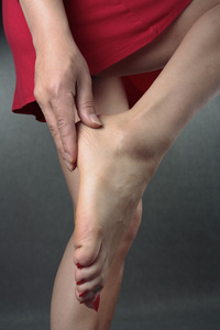 妇女按摩疼痛的脚