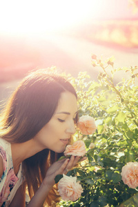 妇女或女孩嗅到的开花的玫瑰花