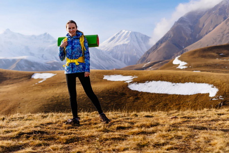 年轻的活跃的女孩喜欢徒步旅行, 徒步旅行的高加索脊带背包和帐篷