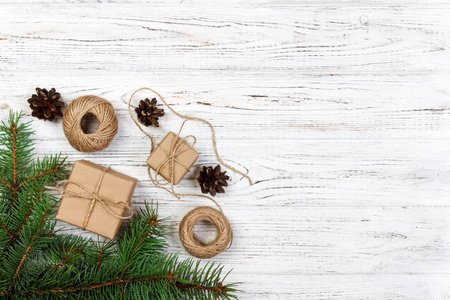 圣诞节装饰元素 串, chrtistmas 树分支与锥体和几个装饰的礼物在白色木背景