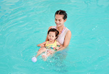 母亲抱着婴儿游泳池培训