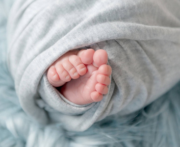 刚出生的婴儿在格子赤脚的特写照片