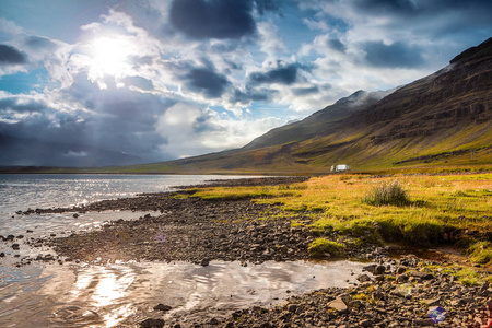 风景如画的山区河流与冰岛在令人惊叹的太阳的传统自然设置
