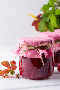 树莓果酱放在排和新鲜覆盆子的罐子