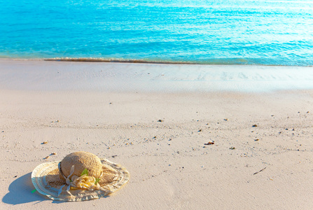 草帽躺在沙上在海的边缘