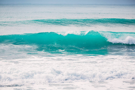 蓝色波浪在印度尼西亚海岸的礁石上断裂