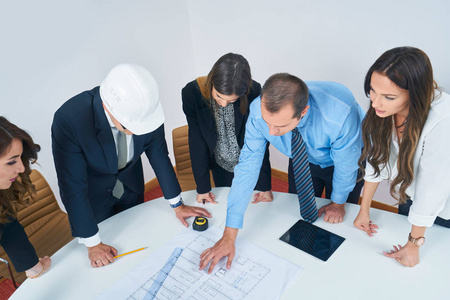 商务人员小组会议与建筑工程师建筑师寻找建设蓝图在现代办公室