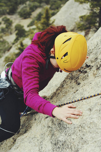 一个年轻女子用绳子从事攀岩运动