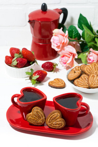 白色背景的两个红色咖啡杯和心形饼干