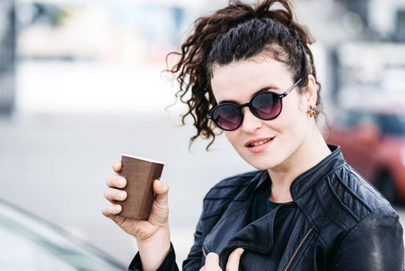漂亮的女孩在大街上喝咖啡