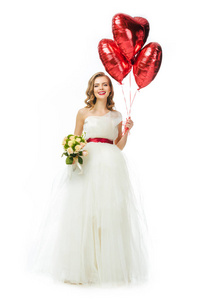 美丽的新娘在婚纱礼服与心形气球隔离在白色
