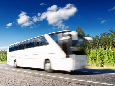 在高速公路上超速行驶的白公共汽车运动模糊