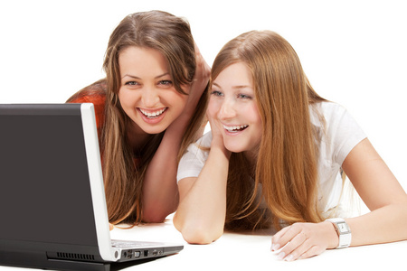 两个年轻快乐的学生女孩在笔记本电脑上工作