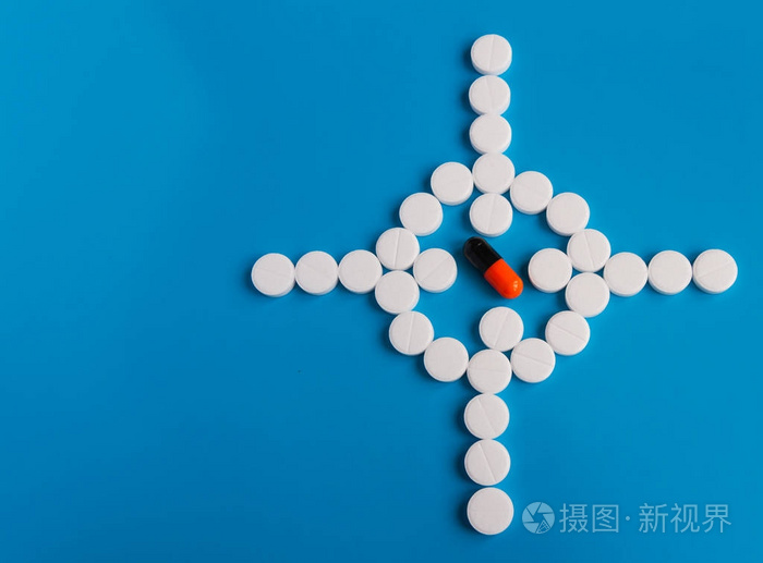 药片白色圆的药物在蓝色背景被放置在视觉的形式在中心色的药丸