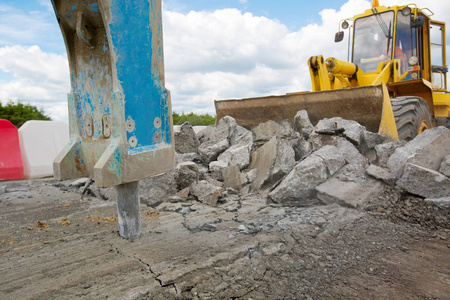 道路施工中大型手提破碎沥青铺装和轮式装载机移动破石