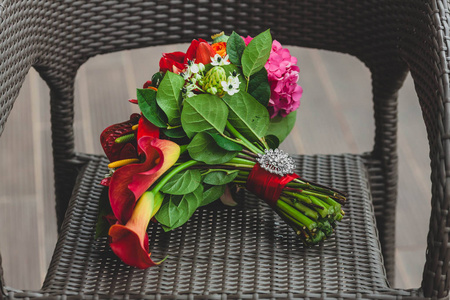 与鲜艳的红色花朵，茎上的银胸针带丝带的婚礼花束。特写镜头。图稿