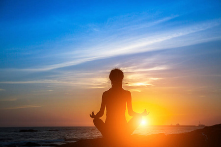 冥想瑜伽妇女剪影在海在惊人的日落