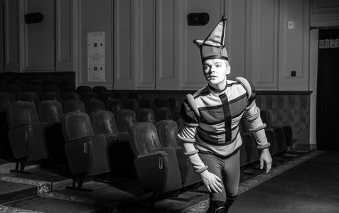 演员穿着小丑的服装在旧剧场的内部。黑白肖像