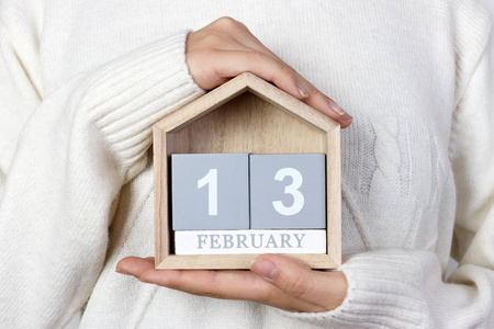 2 月 13 日在日历中。女孩拿着一个木制的日历。世界无线电日