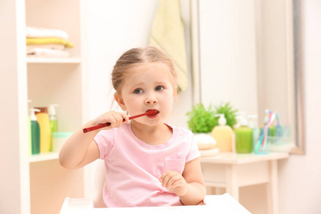 可爱的小女孩在浴室刷牙