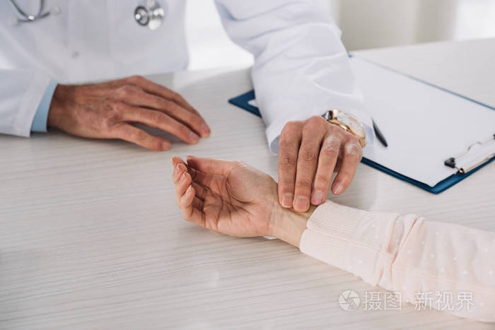 医生测量女性患者脉搏的裁剪图像
