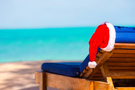 太阳躺椅与圣帽在美丽的热带海滩, 白色的沙子和绿松石水。完美的圣诞假期
