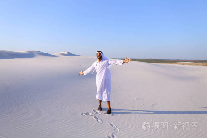 快乐的阿拉伯男人走在中间的白色沙漠和享有生活 o