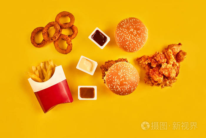 顶视图汉堡包 炸薯条和炸鸡在黄色背景上.复制空间为您的文字