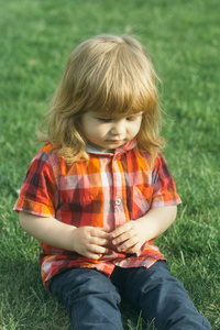 在绿色草地上的小宝贝男孩。