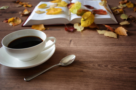 一张小木桌上一杯咖啡和一本书的对象