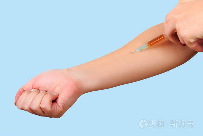 特写的手 给病人注射用棕色药物注射器.上臂无菌注射