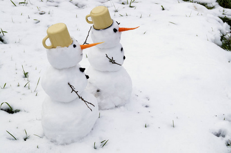 雪中手工制作的两堆雪人图片