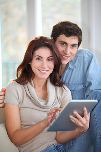 年轻夫妇在家里用电子平板电脑