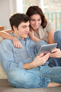年轻夫妇在家里用电子平板电脑