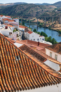 梅尔图拉的瓦片屋顶与桥在瓜迪亚纳河河。Merto