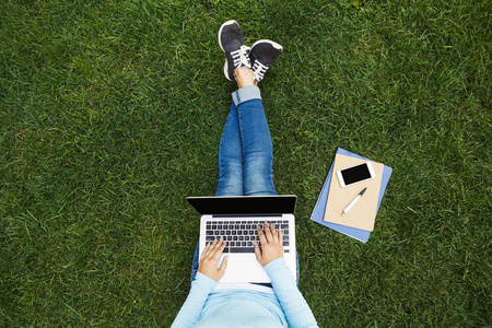 笔记本电脑在草地上的女孩