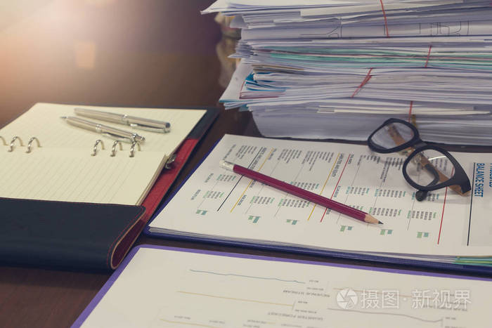 办公和财务概念办公室工作一堆未完成的文件在办公桌上特写铅笔与栈的
