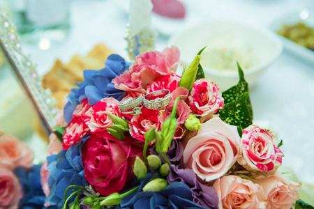 多色的婚礼花束花。结婚花束与珍珠和圆环。多色玫瑰戒指结婚花束