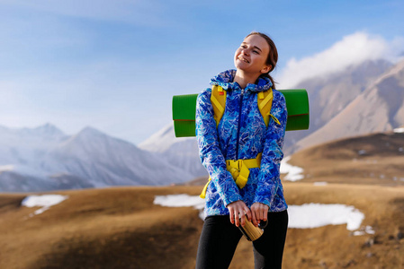 快乐的年轻女孩穿着蓝色夹克享受旅行和阳光