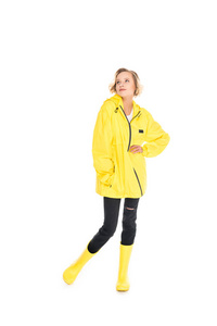 梦幻般的年轻女子在时尚的黄色雨衣和雨靴隔离在白色