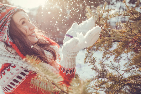 穿红毛衣的年轻女子扔雪。冬季活动