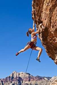 女攀岩者紧贴悬崖。