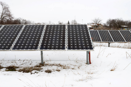 照片拼贴的太阳能电池板和风力汽轮机在冬天与雪可持续资源的概念