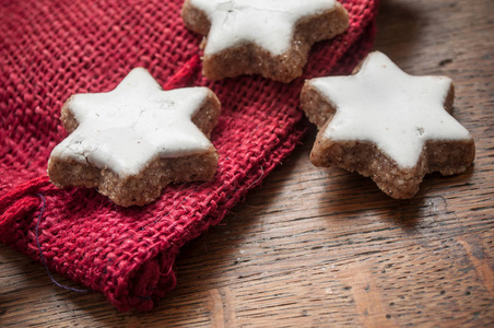 木制背景下装饰粗麻布袜子的圣诞面包形状明星