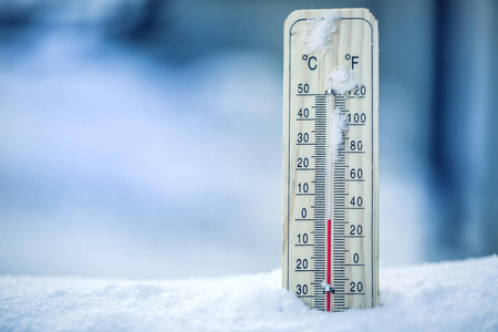温度计在雪显示低温零。摄氏温度和华氏度的低温。寒冷的冬季天气摄氏三十二氏