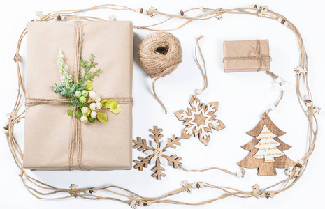 经典的圣诞礼品盒, 在棕色的纸与玩具和新年装饰白色的礼物。圣诞贺卡背景