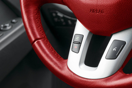 免提和媒体控制在黑色皮革制品，现代汽车内饰红色的方向盘上的按钮