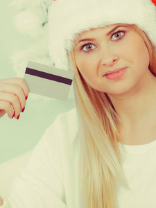 圣诞老人的帽子持有信用卡的女人